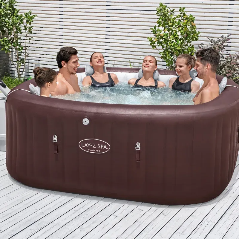 Six adultes assis dans le Lay-Z-Spa Maldives HydroJet Pro installé sur une terrasse en bois