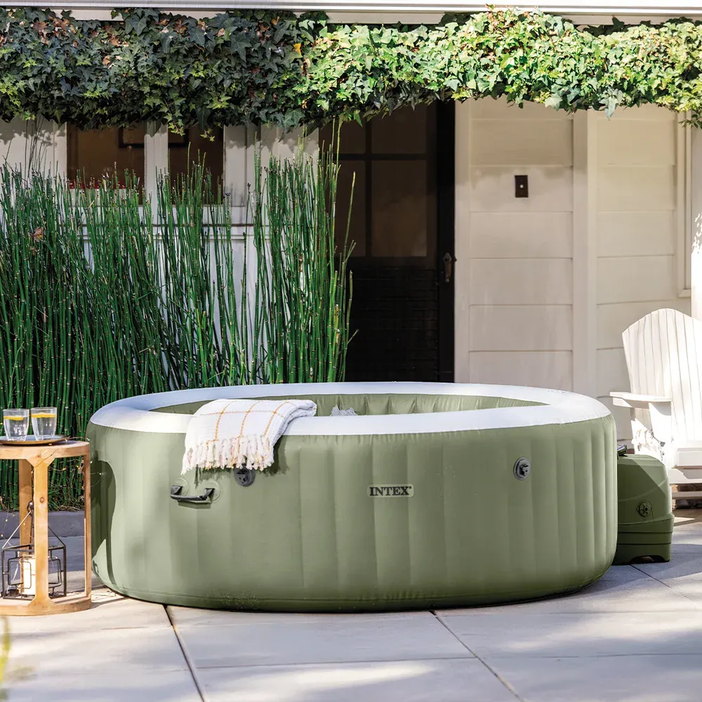 Le spa Olive installé sur une terrasse dallée, couvercle gonflable en place, bloc technique visible sur le côté